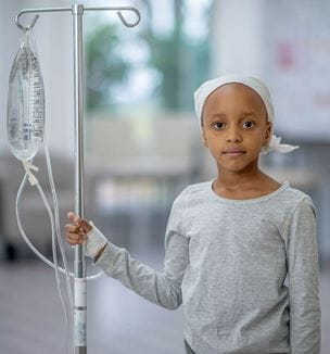 Getty image of young African American cancer patient with IV pole