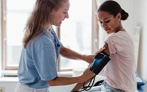Teen girl takes blood pressure test