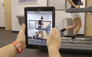 using an ipad  to record man on treadmill