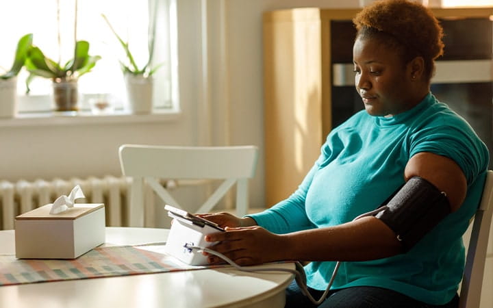 woman checks blood pressure at home