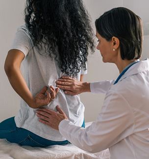 Doctor examining patient with lower back pain