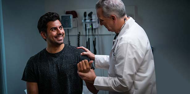 Doctor checking male patient in office