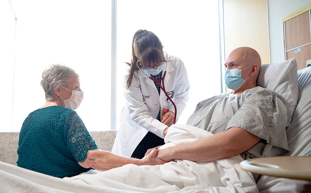 Dr. Molly Gallogly treats her patient Jack Boyle as his wife Judi Boyle holds his hand