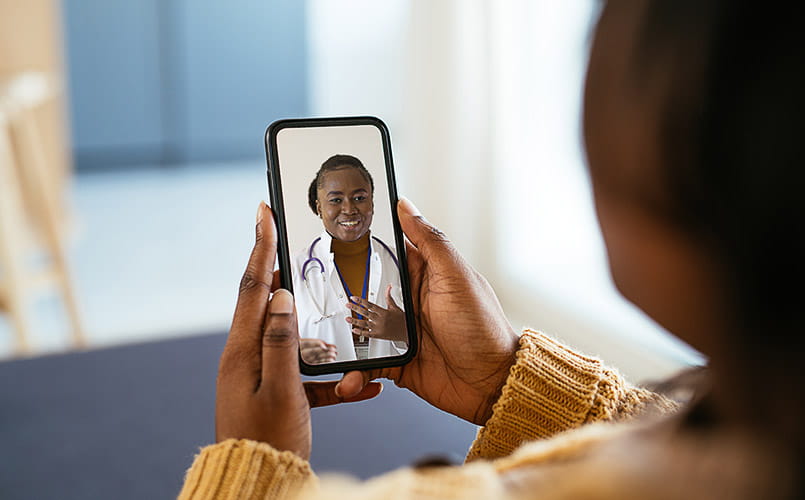 A woman using a digital device during illness, talking to doctor on video call